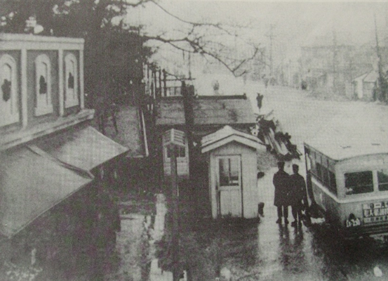 写真４　左手前が向島市場
同市場は昭和4年に開設された。水戸街道に面し前にはバス停があった。左手奥の樹木は秋葉神社の杜。水戸街道も神社の境内であった。

